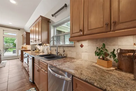 a kitchen with stainless steel appliances granite countertop a sink stove and cabinets