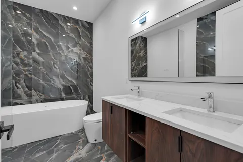 a bathroom with a sink a toilet and a mirror