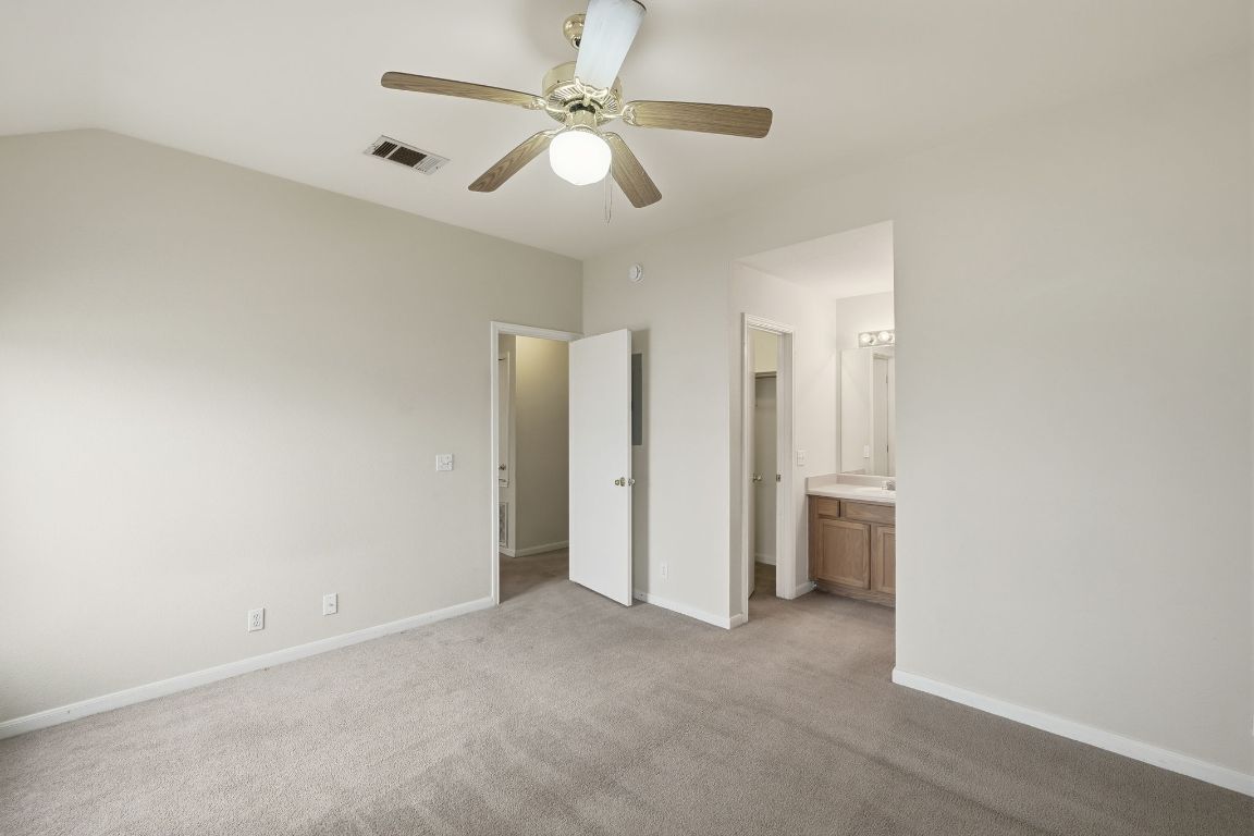 3201 E El Salido Parkway, Unit 511 Cedar Park, TX 78613 - Photo 7 of 12 Unfurnished bedroom with carpet floors, ceiling fan, ensuite bathroom, and lofted ceiling