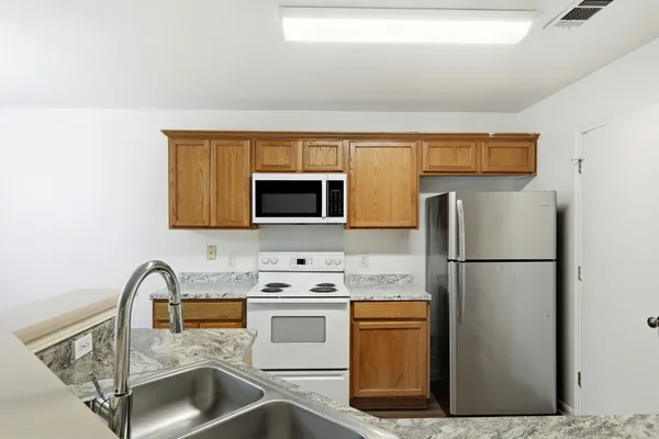 a kitchen with stainless steel appliances a refrigerator stove and microwave
