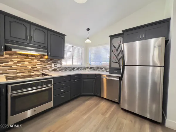 a kitchen with stainless steel appliances sink a stove and cabinets