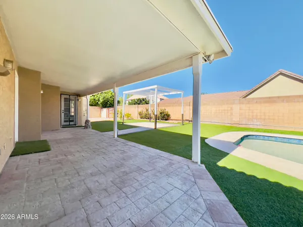 a view of a backyard with table and chairs under an umbrella
