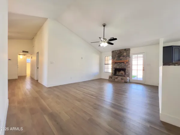 a view of empty room with a fireplace and wooden floor