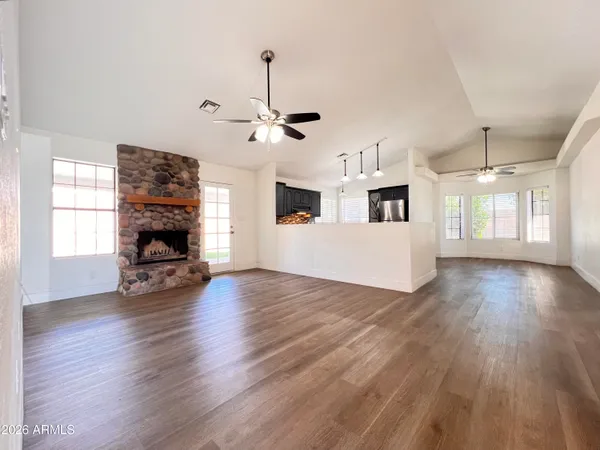 a view of a livingroom with furniture wooden floor a flat screen tv and a fireplace