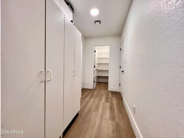a view of a hallway with wooden floor and entryway