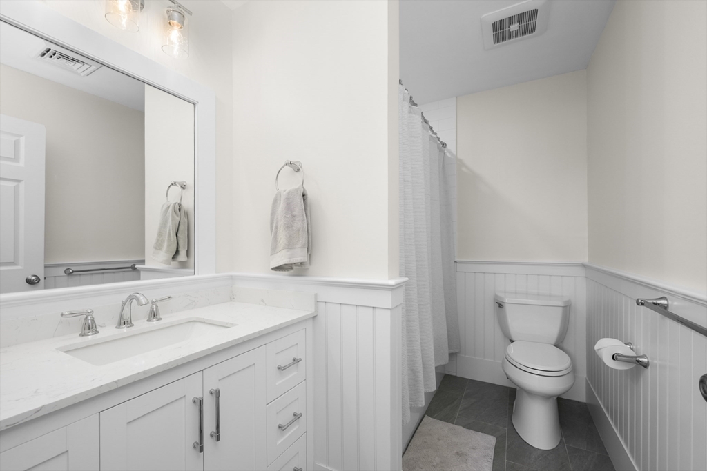 231 Route 28, Unit 20 Harwich, MA 02671 - Photo 15 of 22 a bathroom with a granite countertop toilet sink and a mirror