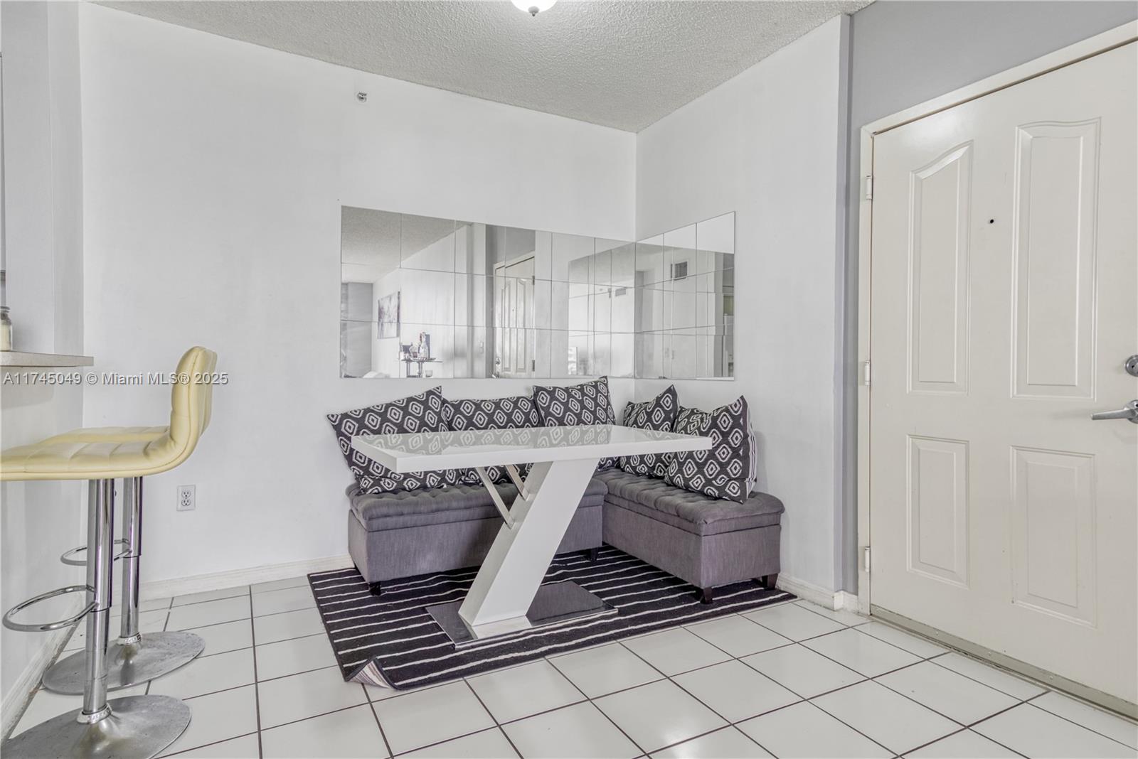 5091 Northwest 7th Street, Unit 1001 Miami, FL 33126 - Photo 13 of 17 a living room with a couch and a table