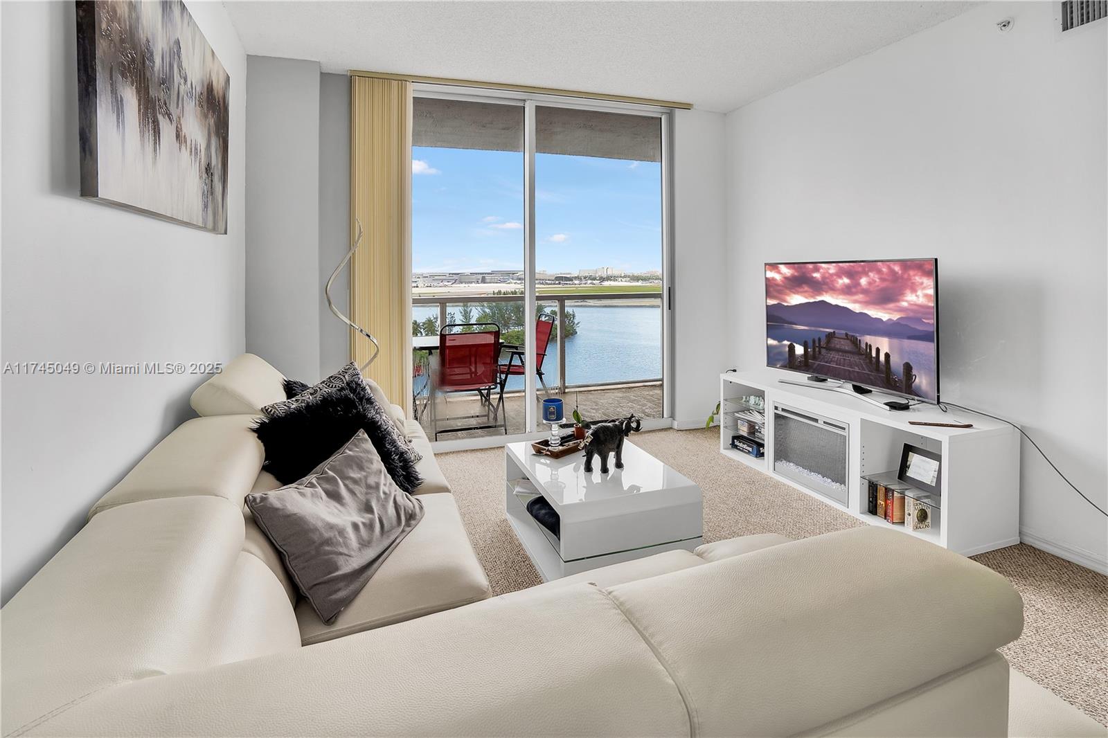 5091 Northwest 7th Street, Unit 1001 Miami, FL 33126 - Photo 5 of 17 a living room with furniture and a flat screen tv