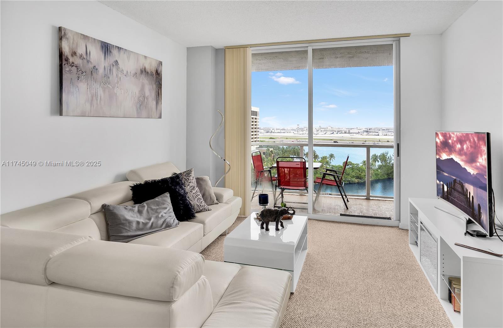 5091 Northwest 7th Street, Unit 1001 Miami, FL 33126 - Photo 6 of 17 a living room with furniture and a flat screen tv