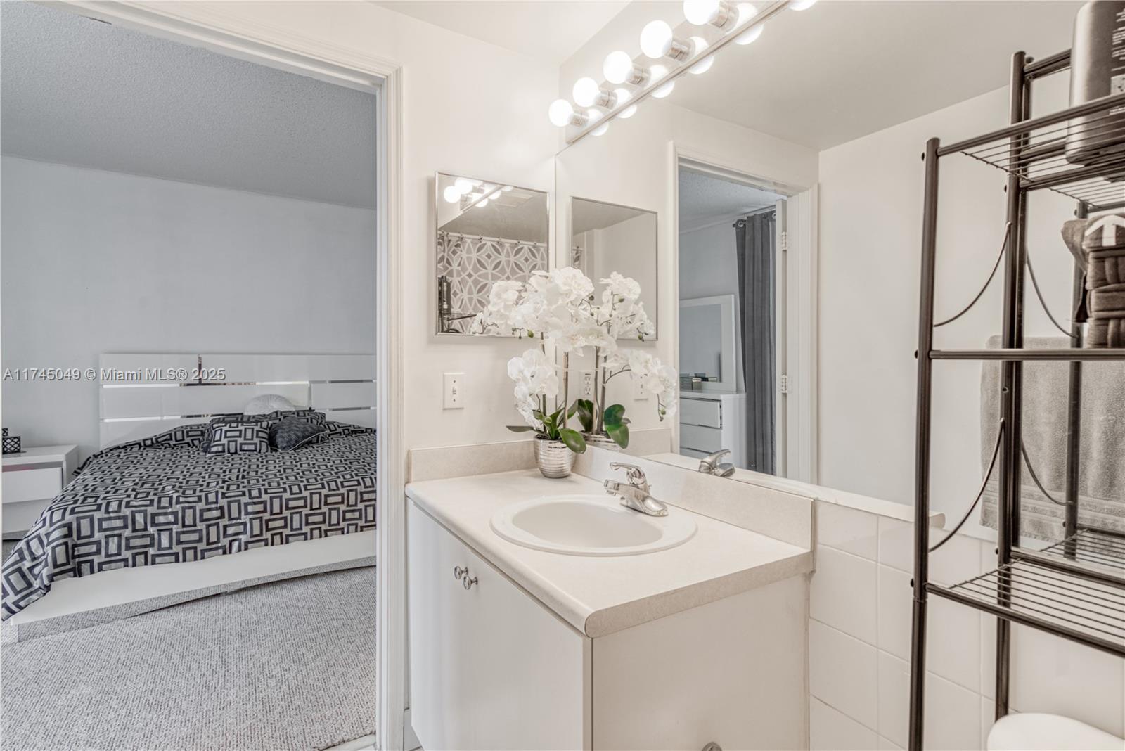 5091 Northwest 7th Street, Unit 1001 Miami, FL 33126 - Photo 9 of 17 a bathroom with a sink a mirror and a shower