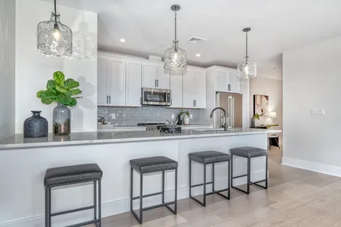 a kitchen with stainless steel appliances kitchen island a table and chairs in it