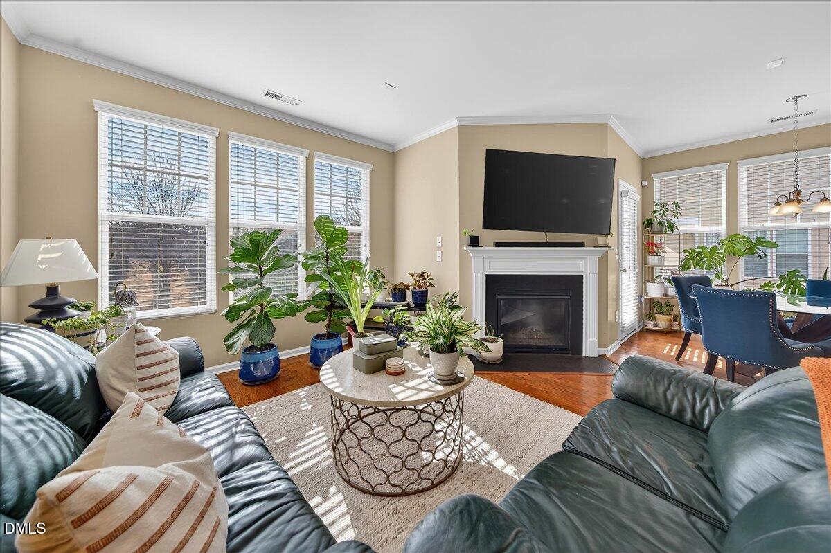 9328 Wooden Road Raleigh, NC 27617 - Photo 15 of 58 a living room with furniture a flat screen tv and a fireplace