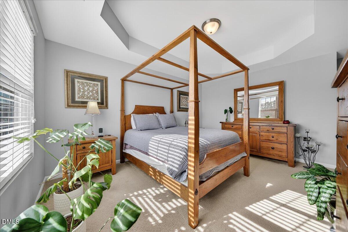 9328 Wooden Road Raleigh, NC 27617 - Photo 33 of 58 a bedroom with a bed and wooden floor