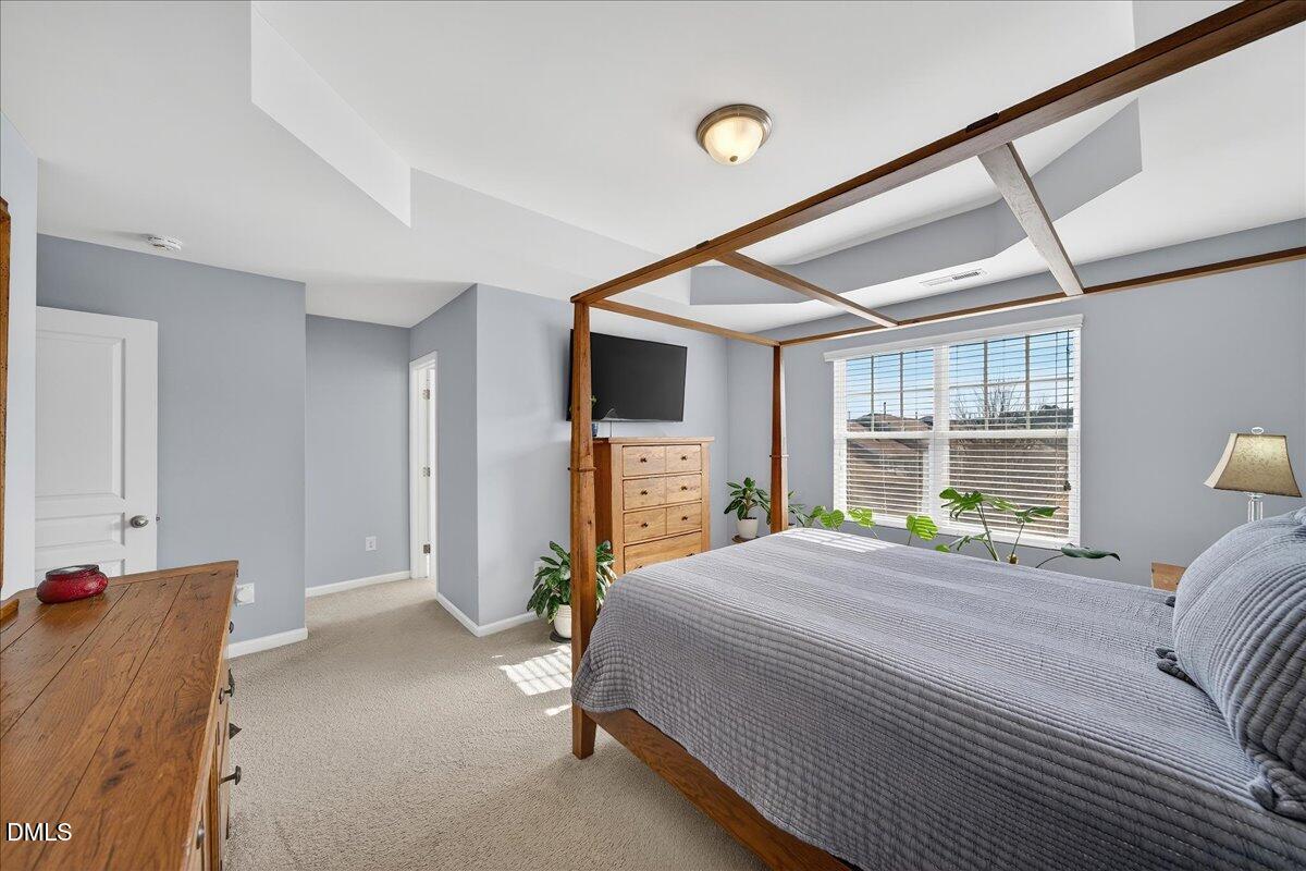 9328 Wooden Road Raleigh, NC 27617 - Photo 34 of 58 a bedroom with a bed and large windows