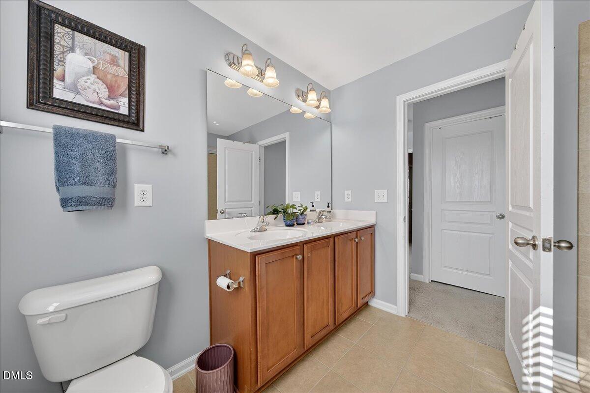 9328 Wooden Road Raleigh, NC 27617 - Photo 35 of 58 a bathroom with a toilet a sink and mirror