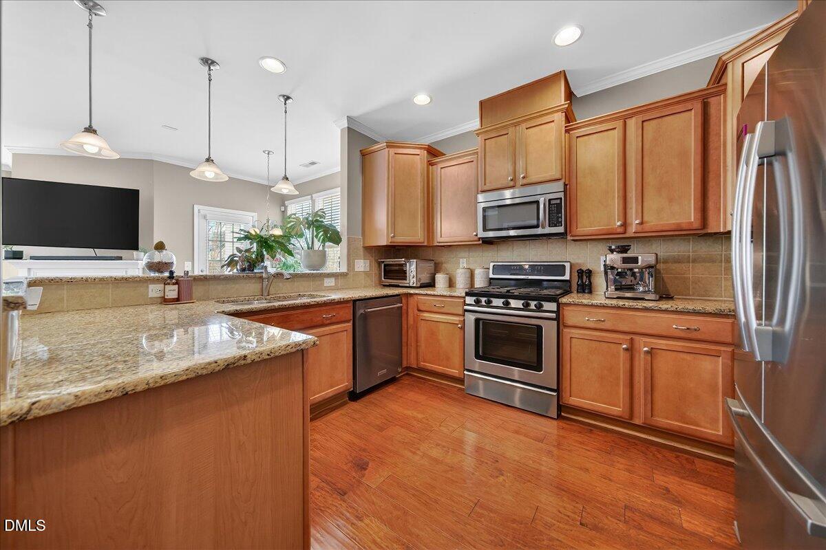 9328 Wooden Road Raleigh, NC 27617 - Photo 5 of 58 a kitchen with stainless steel appliances granite countertop a sink a stove and a refrigerator