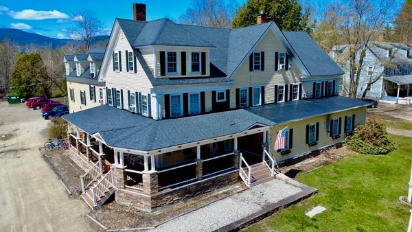 a view of a house with a yard and deck