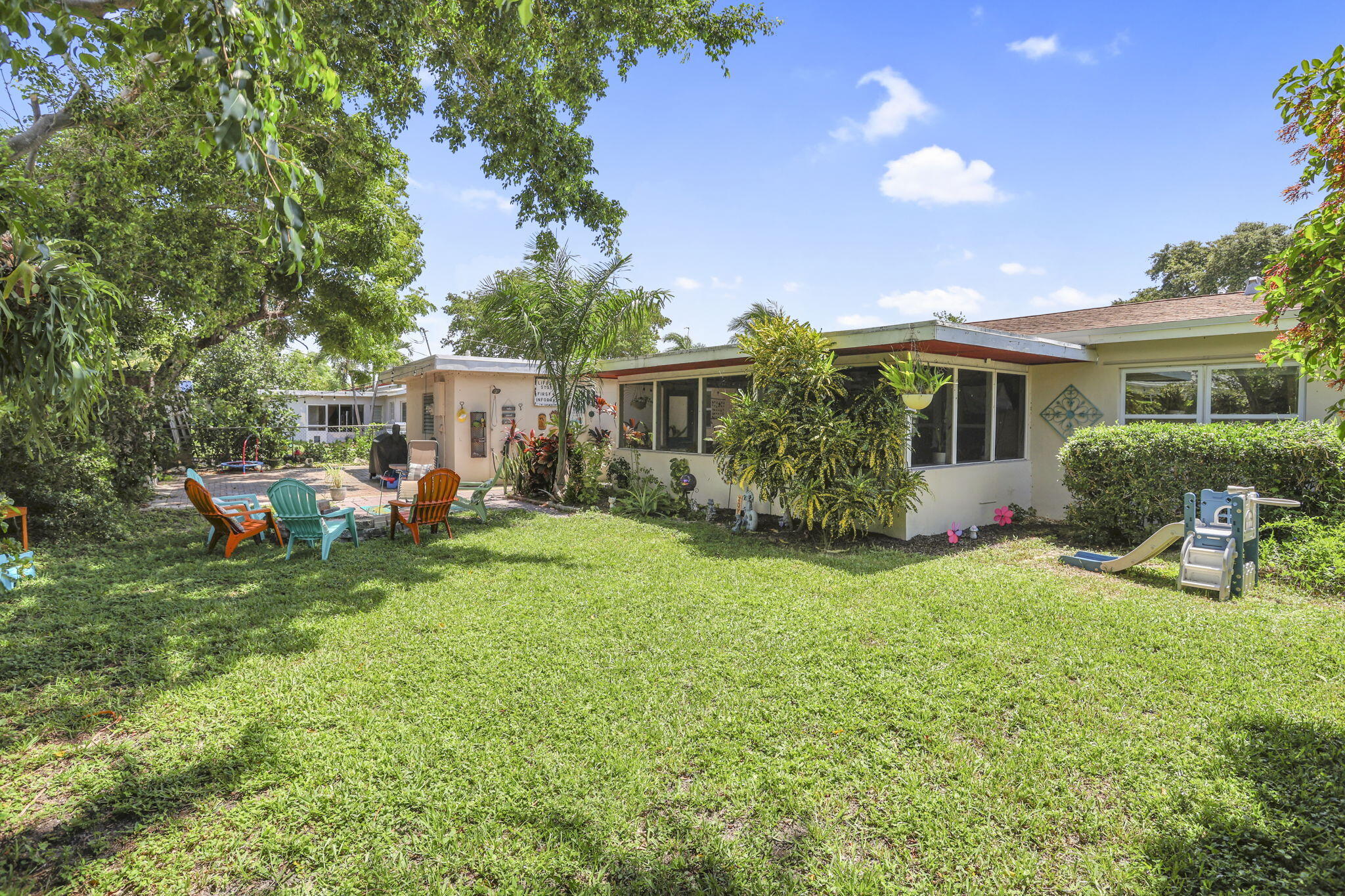 1707 High Ridge Road Lake Worth, FL 33461 - Photo 28 of 36 a view of a house with backyard sitting area and garden