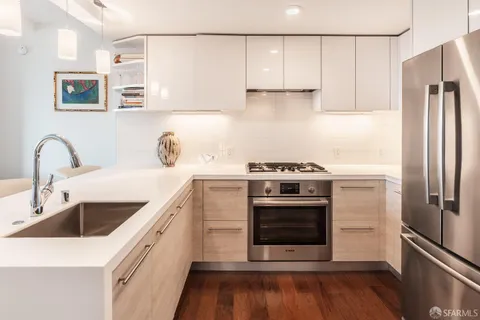 a kitchen with stainless steel appliances a stove a sink and a refrigerator
