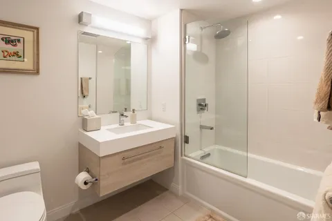 a bathroom with a bathtub shower sink vanity and a toilet