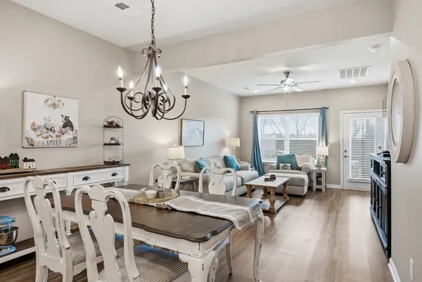 a view of a dining room with furniture wooden floor and a chandelier