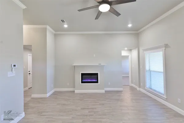 a view of an empty room with window and fire place
