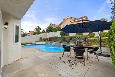 a view of backyard with table and chairs under an umbrella