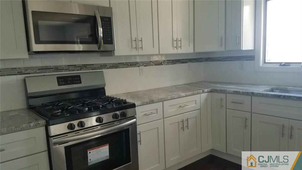 23 Ferris Road Edison, NJ 08817 - Photo 10 of 21 a kitchen with granite countertop white cabinets and stainless steel appliances