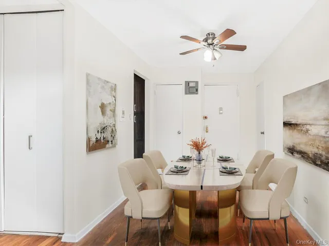 a view of a dining room with furniture and a chandelier fan
