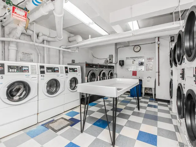 a utility room with dryer washer and a kitchen view