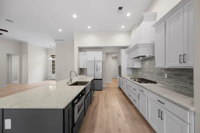 a kitchen with stainless steel appliances granite countertop a sink stove and refrigerator