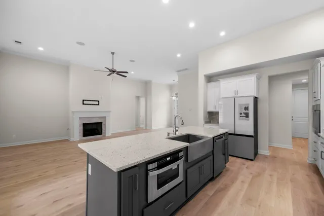 a kitchen with granite countertop white cabinets and white appliances