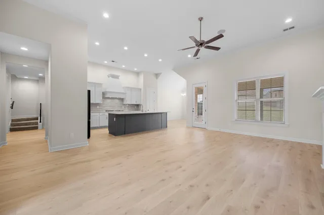 a view of an empty room with a window and fireplace