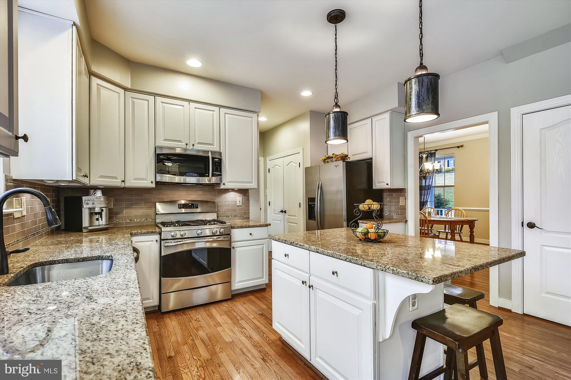 484 Stratford Road Fallston, MD 21047 - Photo 12 of 44 a kitchen with stainless steel appliances granite countertop a sink a stove a refrigerator a microwave oven with a dining table and chairs
