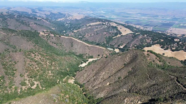 an aerial view of mountain with an ocean