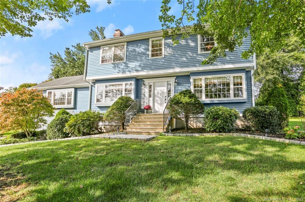 a front view of house with yard and green space