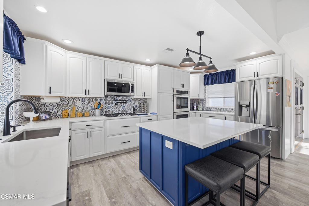 2497 Orangewood Place Simi Valley, CA 93065 - Photo 11 of 42 a kitchen with white cabinets a sink stove and refrigerator