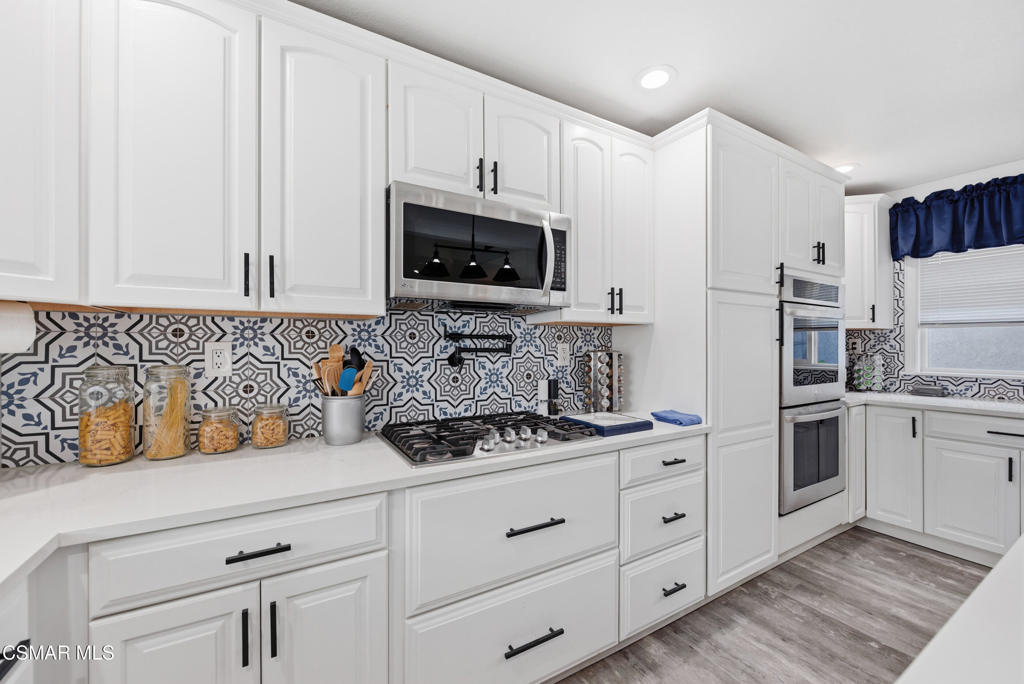 2497 Orangewood Place Simi Valley, CA 93065 - Photo 12 of 42 a kitchen with white cabinets and white appliances
