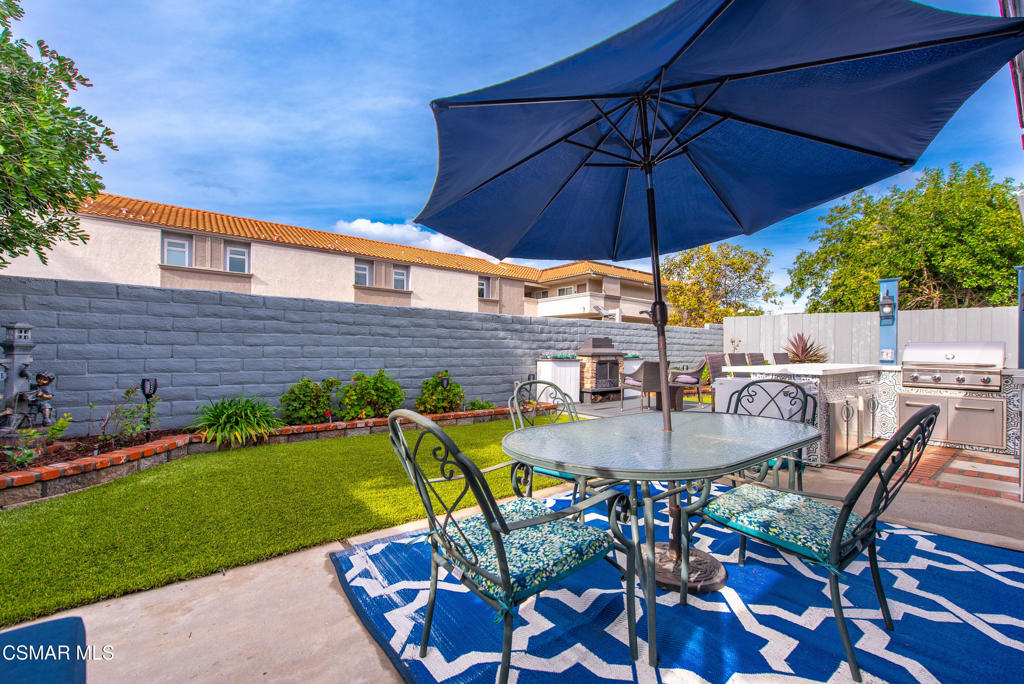 2497 Orangewood Place Simi Valley, CA 93065 - Photo 33 of 42 a patio with a table and chairs under an umbrella