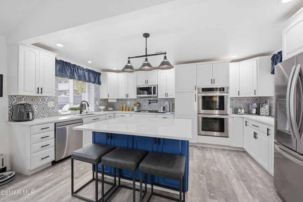 2497 Orangewood Place Simi Valley, CA 93065 - Photo 10 of 42 a kitchen with white cabinets and stainless steel appliances