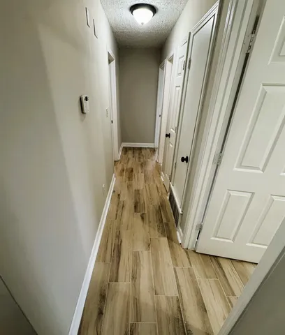 a view of a hallway with wooden floor and staircase