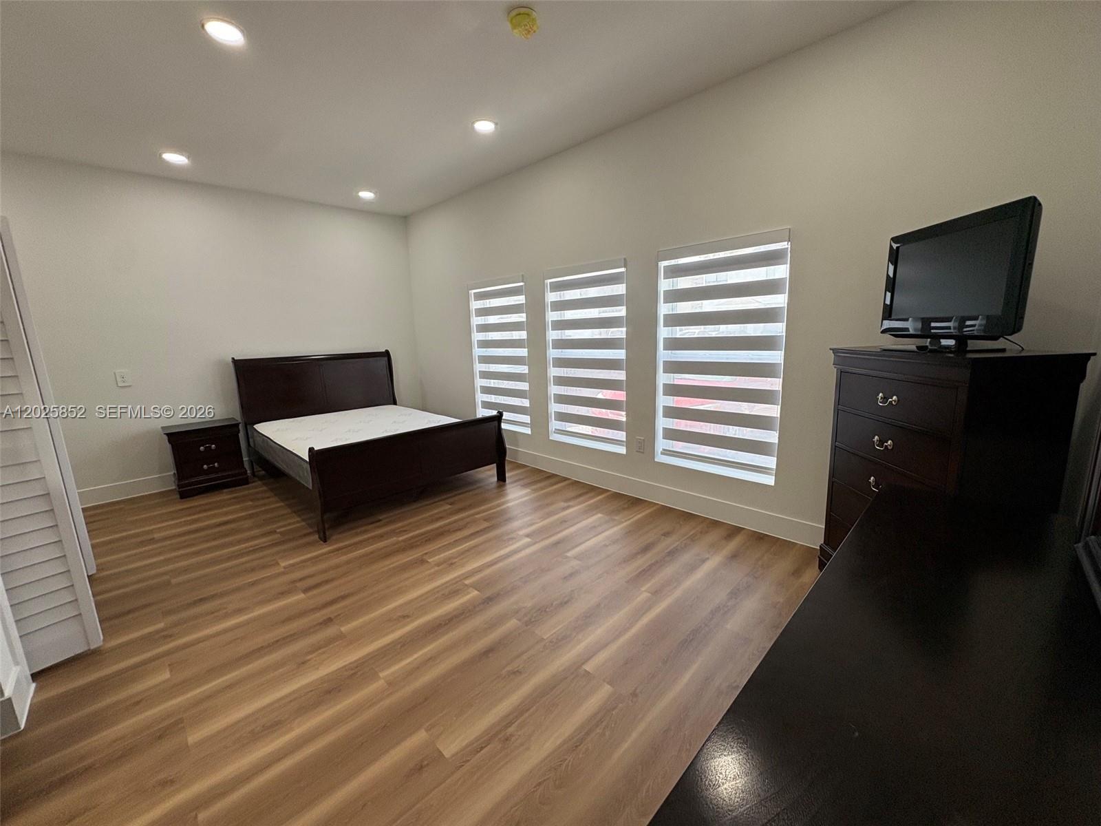 12948 Southwest 265th Terrace, Unit STUDIO Homestead, FL 33032 - Photo 10 of 16 a living room with furniture and a flat screen tv