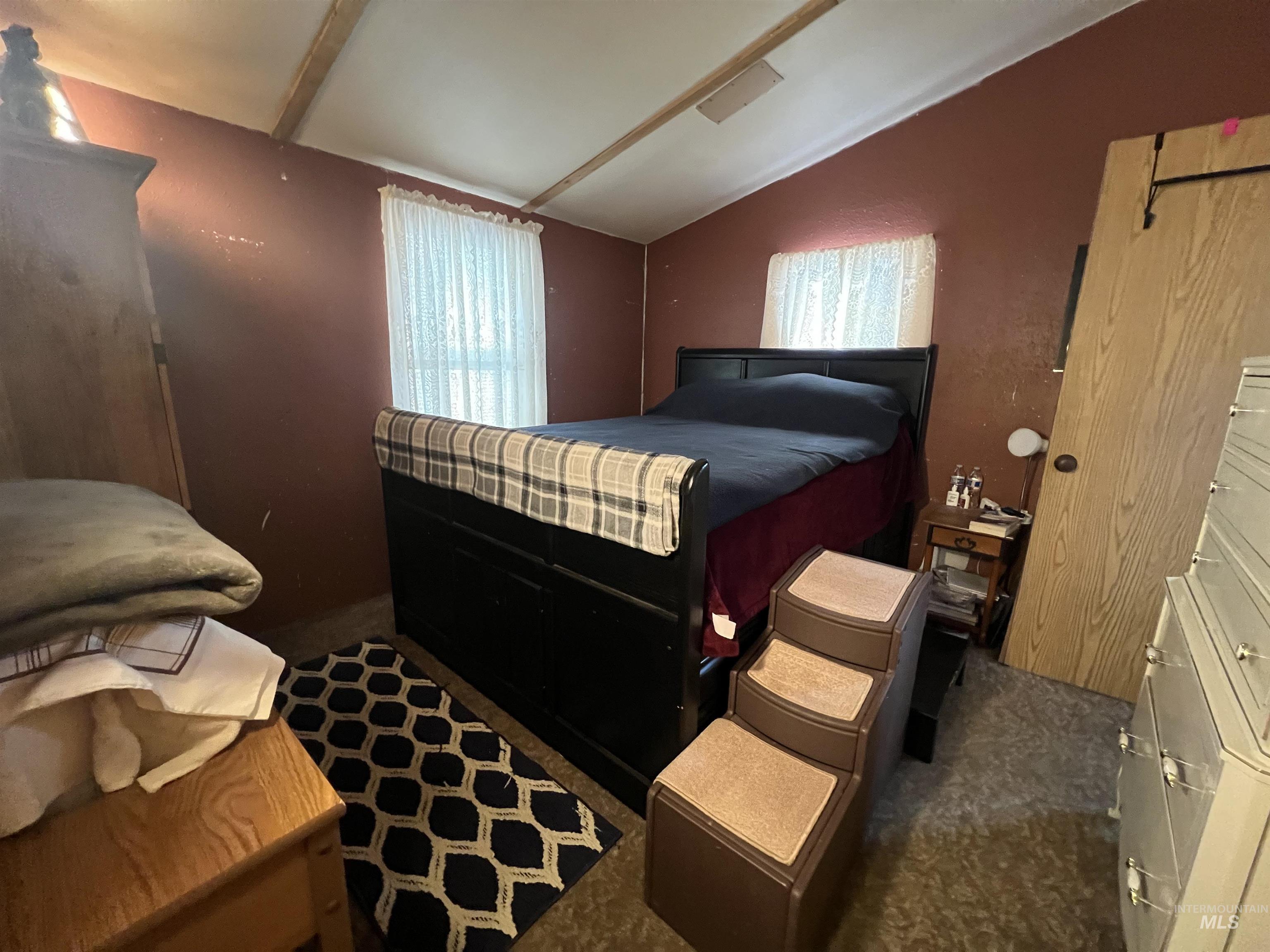 23743 Stephen Lane Parma, ID 83660 - Photo 33 of 34 Bedroom with multiple windows, vaulted ceiling, and dark colored carpet