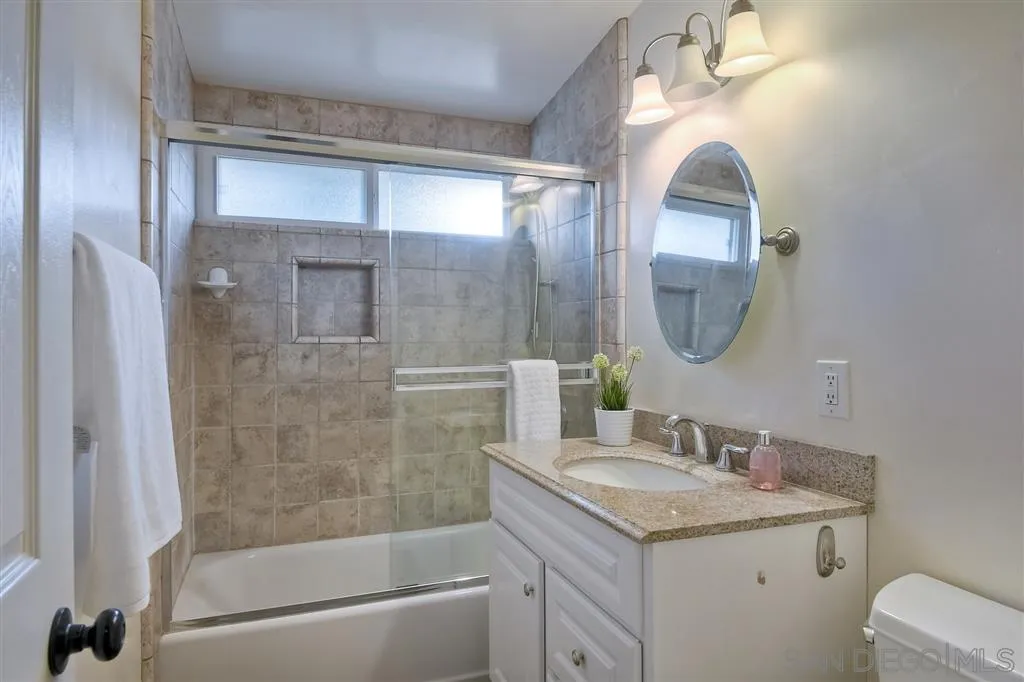 13733 Powers Road Poway, CA 92064 - Photo 14 of 23 a bathroom with a granite countertop sink a mirror and a shower