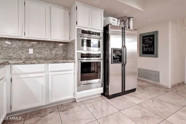 a kitchen with white cabinets stainless steel appliances and sink