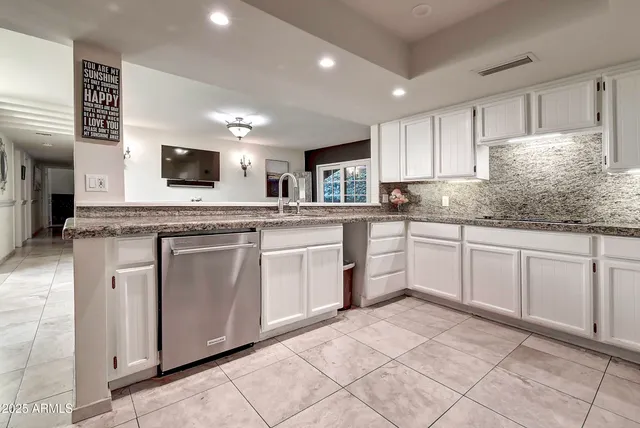 a bedroom with a large bed a flat tv screen and a bookshelf