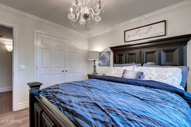 a bedroom with a bed and a chandelier