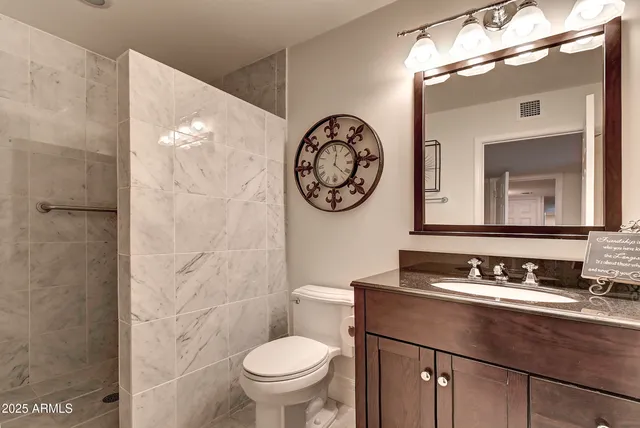 a bathroom with a sink toilet mirror and shower