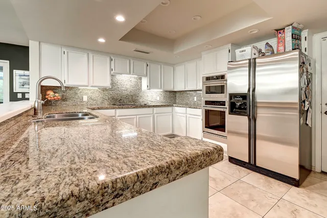 a kitchen with kitchen island a counter top space cabinets and stainless steel appliances