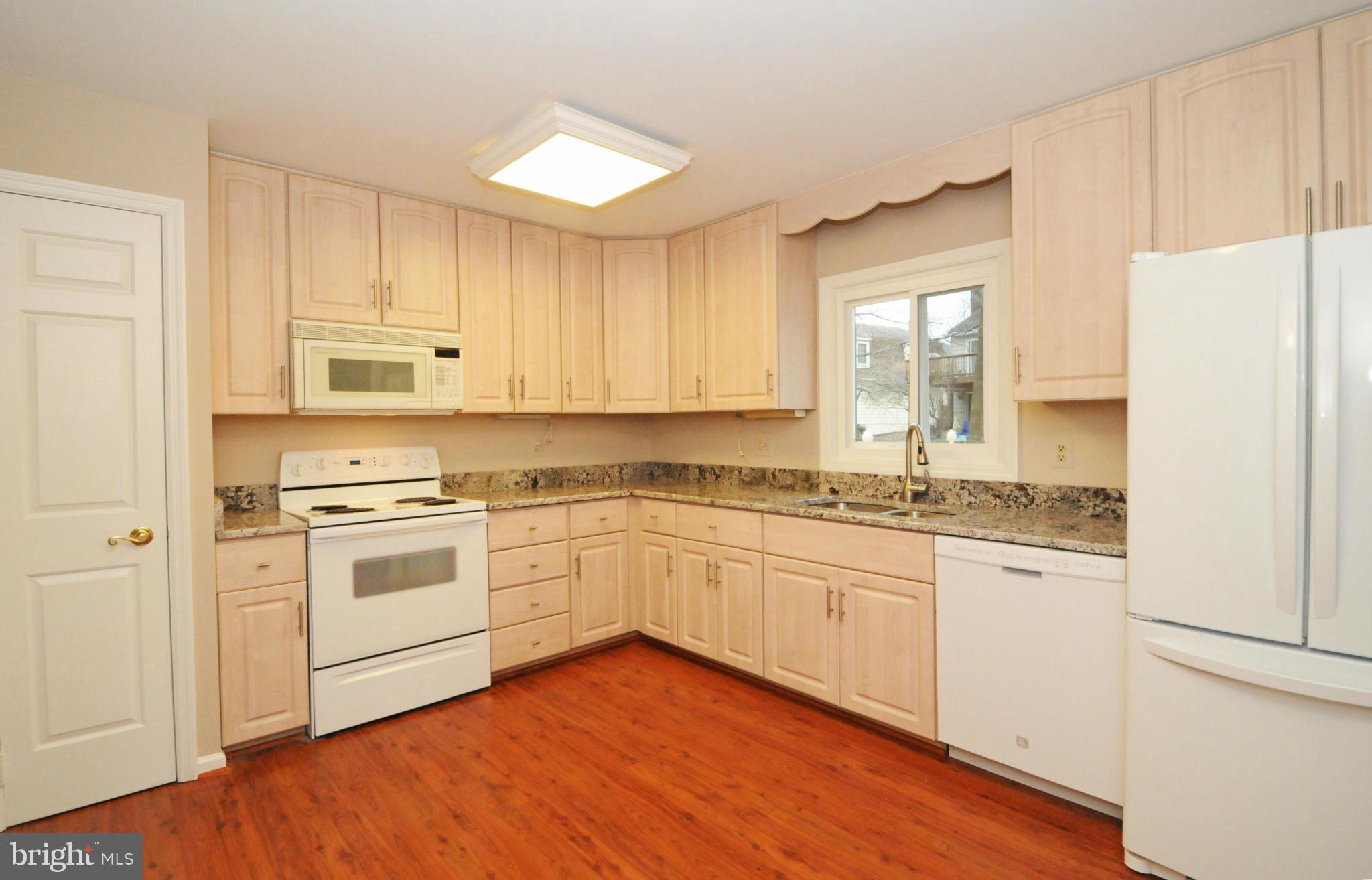 8425 Blevins Way Court Vienna, VA 22182 - Photo 15 of 30 a kitchen with granite countertop white cabinets and white appliances